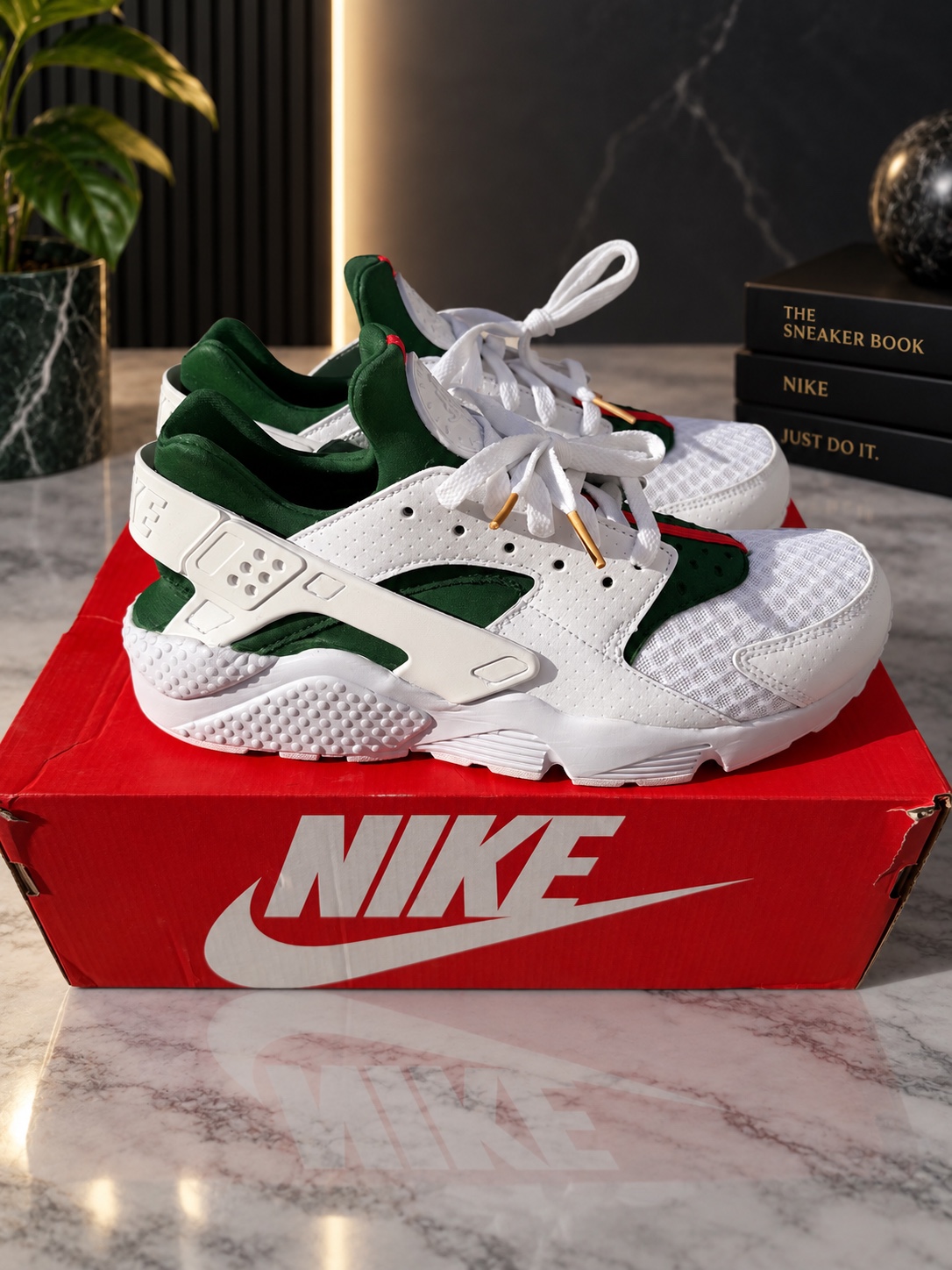 White, green and red custom Nike Air Huaraches in side profile on their original red Nike box